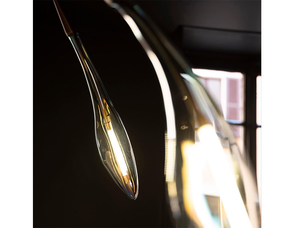A detailed view of the Hen Maple ceiling light reveals its organic teardrop-shaped glass diffuser and warm bronze stem. The glowing interior emphasizes the fixture’s refined craftsmanship and elegant lighting presence.