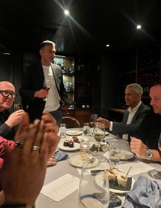 Guests enjoy a warm moment of connection over wine and conversation.