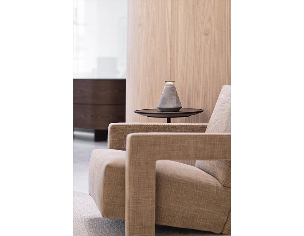 AOI Vase showcases a conical stone form in muted gray, topped with a polished brass detail that highlights its minimalist, sculptural elegance.