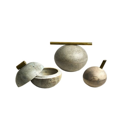 Bola Sabao Accessories combine round stone forms with refined brass details, creating timeless decorative objects with a contemporary sculptural character.