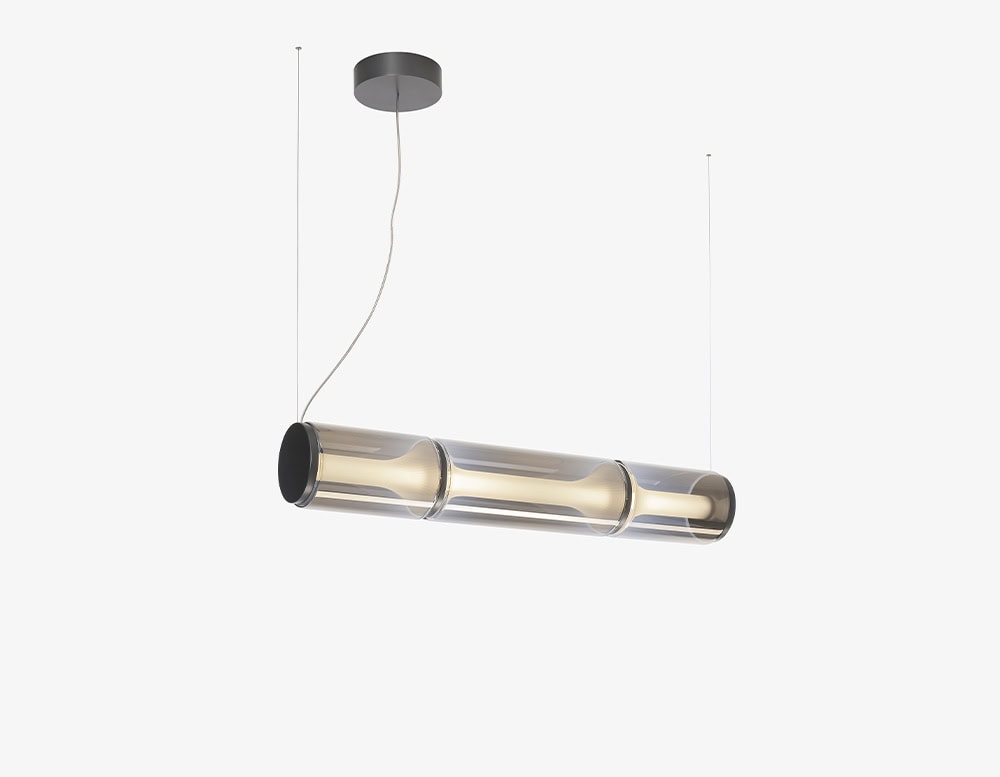 A sleek pendant light with a tubular smoked glass body and soft diffused glow, bringing a refined modern touch to dining or living spaces.