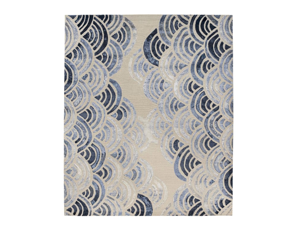 With a motif echoing the rhythm of waves, this rug features overlapping blue arcs on a neutral ground. Its detailed design brings harmony, texture, and a touch of coastal sophistication to the space.