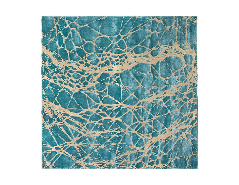 Sah Maze Rug combines vibrant turquoise with a golden vein-like pattern inspired by natural stone textures. Its striking contrast and organic design bring bold elegance to contemporary interiors.