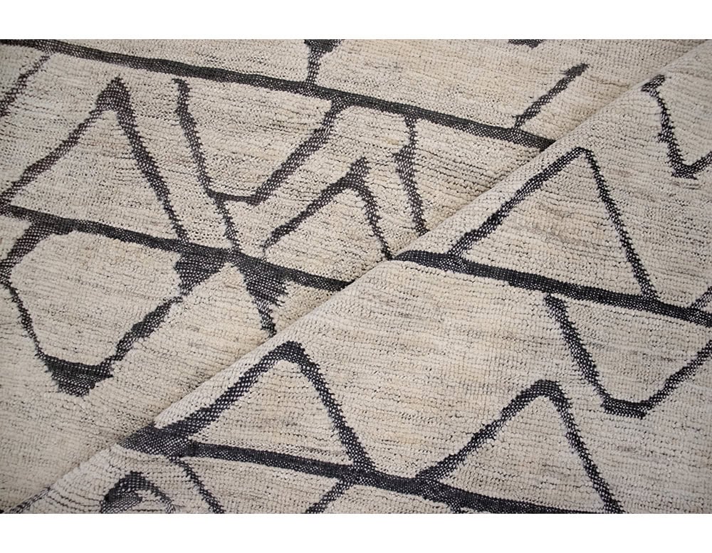 Sah Taza Rug features bold geometric patterns in dark contrast over a natural base. Its handwoven texture blends traditional craftsmanship with modern design, bringing character and balance to any interior setting.