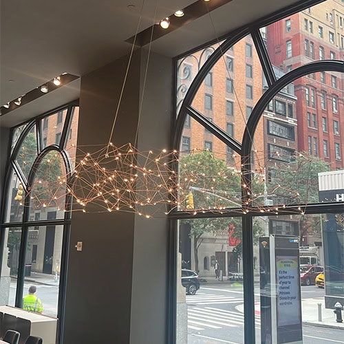 A dramatic suspended lighting fixture with a web of interconnected glowing nodes, bringing a modern artistic touch and warm illumination to the interior.
