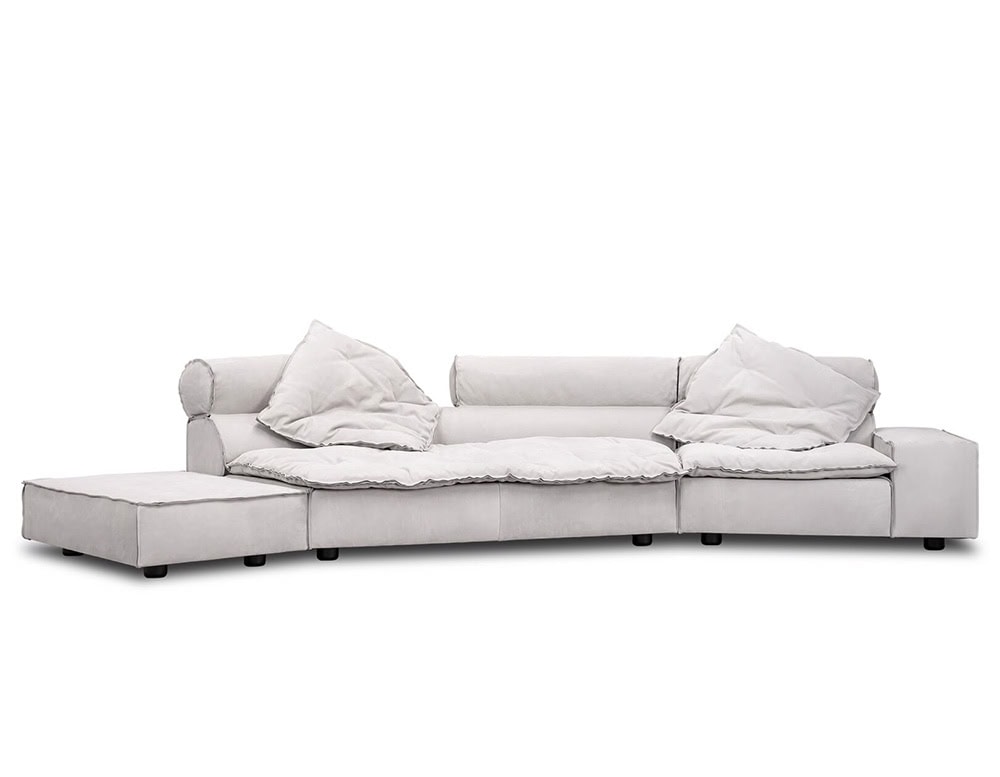 A modular sofa in soft gray fabric with plush cushions and relaxed edges, combining comfort and sophistication in a minimalist form that enhances any contemporary living space.