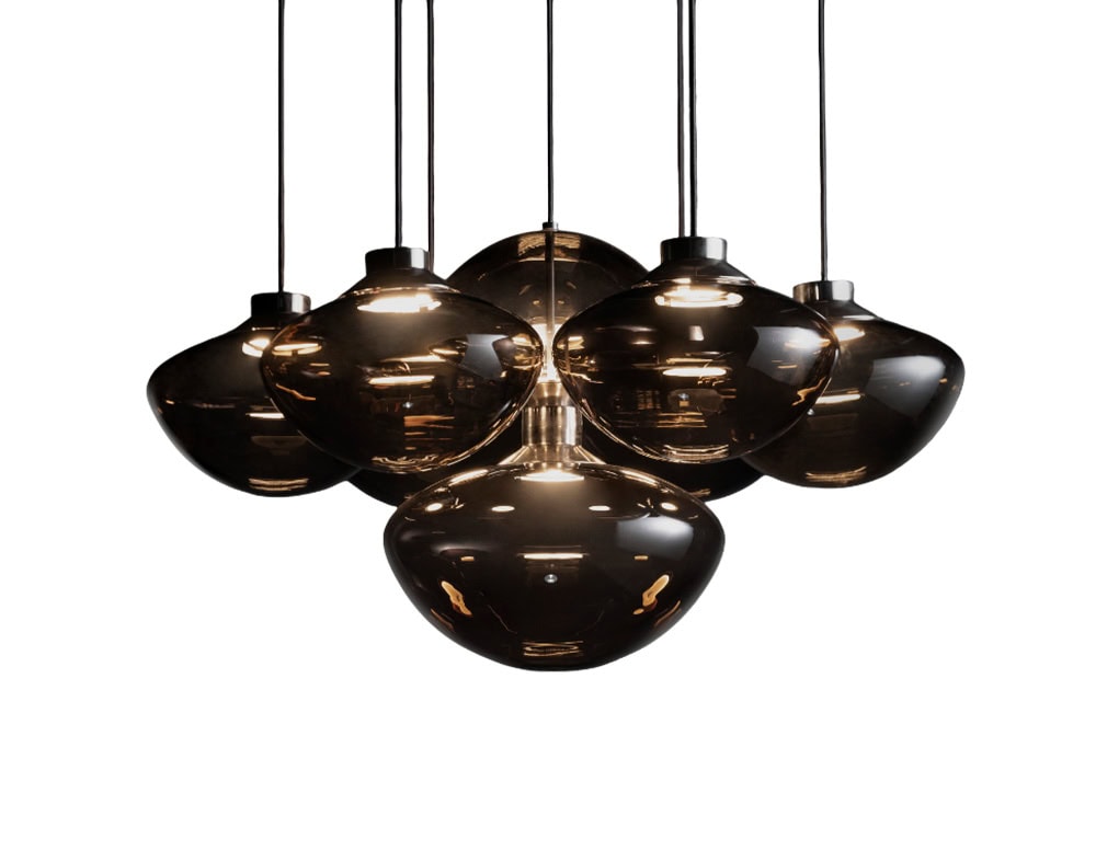 This ceiling light features seven suspended glass shades with a deep, smoky hue. Their smooth contours and soft reflections bring an elegant, atmospheric presence to any contemporary interior.