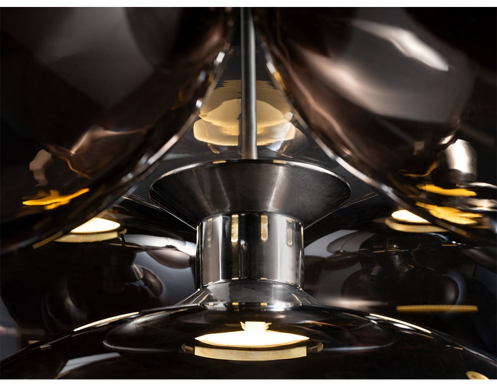 Detail view of the Floyd Seven pendant shows luminous reflections and precision metalwork. The soft diffusion of light through smoked glass enhances its sculptural and contemporary character.
