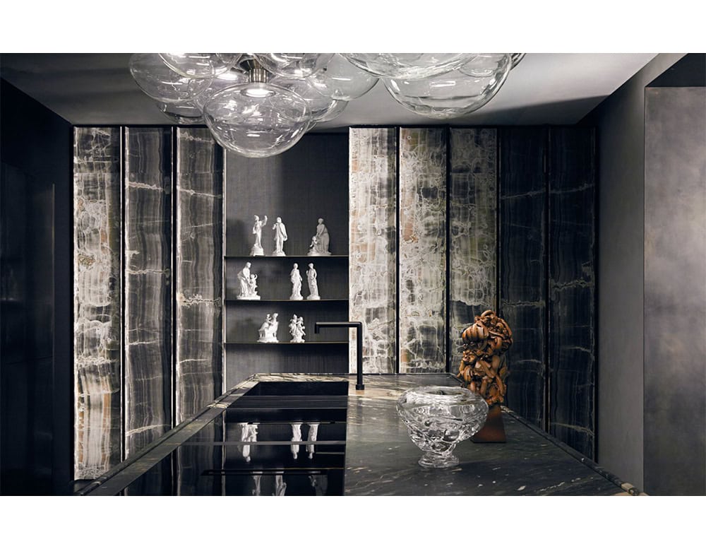 The Floyd Seven ceiling light brings a sculptural glow to a dramatic space. Its clear glass pendants hover above marble and onyx surfaces, enhancing the room’s refined balance of light, texture, and reflection.