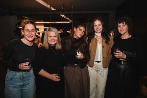 A lively moment among guests enjoying cocktails and conversation, capturing the friendly energy that filled the showroom throughout the night.