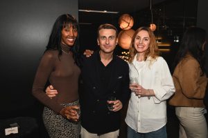 Guests pause for a photo during the evening surrounded by soft lighting and finely crafted pieces that set the tone for a relaxed and stylish night in the showroom.