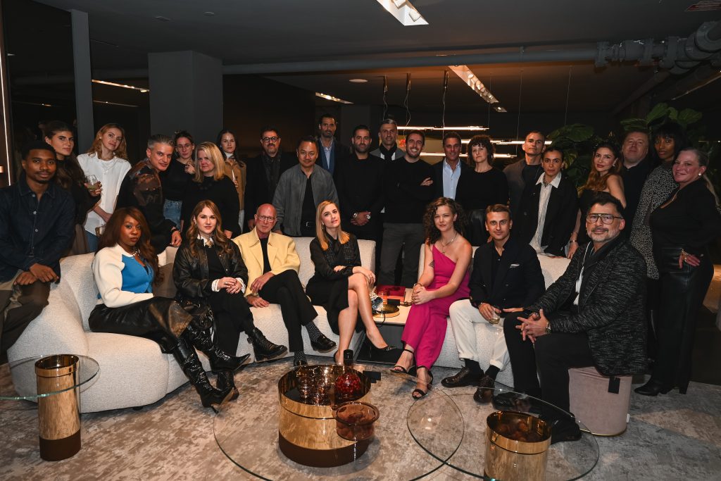 Guests gather for a lively group photo, filling the showroom with energy as they settle into the elegant seating and enjoy an evening surrounded by standout contemporary design.