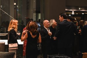 Guests gather in warm conversation as the evening unfolds, enjoying lively exchanges and the inviting ambiance of the designer showroom.