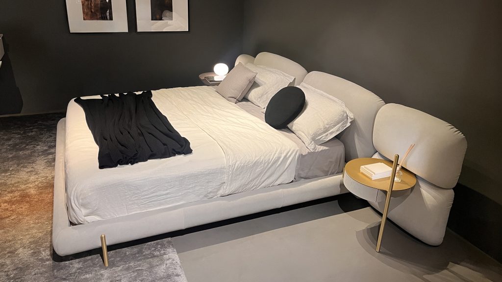 Stone Bed by Baxter featuring a low upholstered frame with softly contoured headboard elements and generous padding designed to create a calm and inviting sleep experience that blends sculptural form with exceptional comfort.