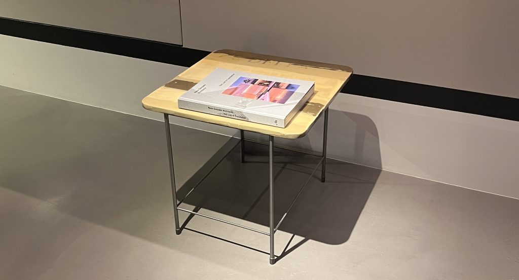 This compact table features a warm yellow surface with soft layered tones that add character. The slim metal frame keeps the look light and modern, making it an easy accent piece beside seating or as a small display table.
