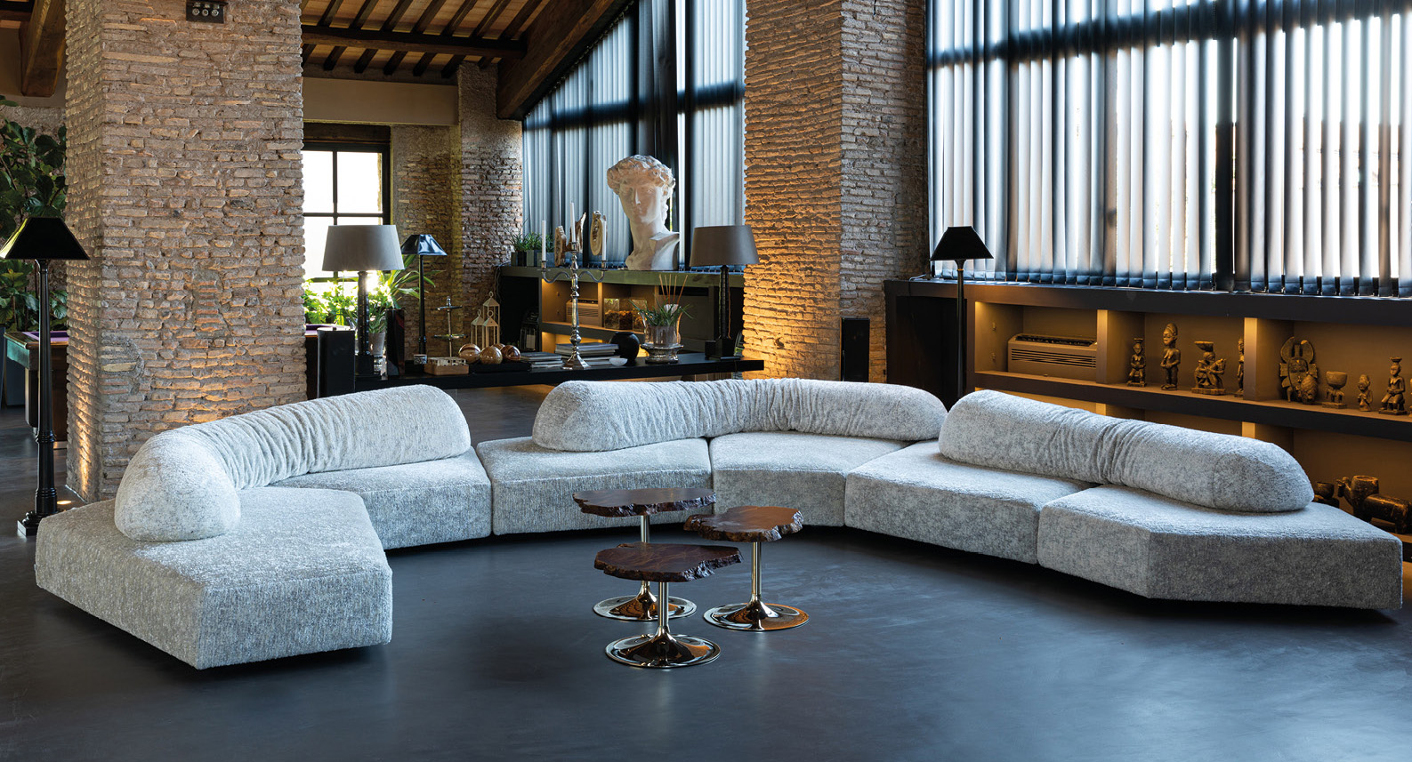 Curved modular On the Rocks sofa in textured light gray fabric featuring rounded cushioned forms and a sculptural layout designed for relaxed seating and contemporary interiors.