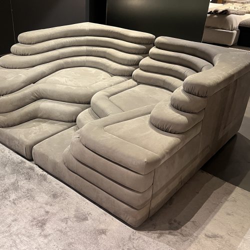 Curved modular sofa featuring generous padding, smooth organic lines, and plush upholstery designed to invite lounging, offering a bold yet understated silhouette that blends comfort, versatility, and modern design appeal.