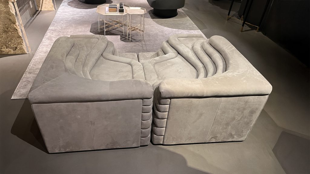Modular sofa composed of softly contoured blocks with layered backrests and generous padding, offering adaptable seating, a tactile upholstered finish, and a sculptural presence defined by smooth lines and balanced proportions.