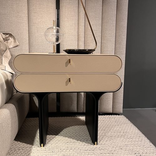 A sculptural bedside piece with two spacious drawers and smooth rounded corners. The warm beige finish pairs with slim gold hardware and a striking black base, giving this nightstand a clean modern look with a touch of luxury.