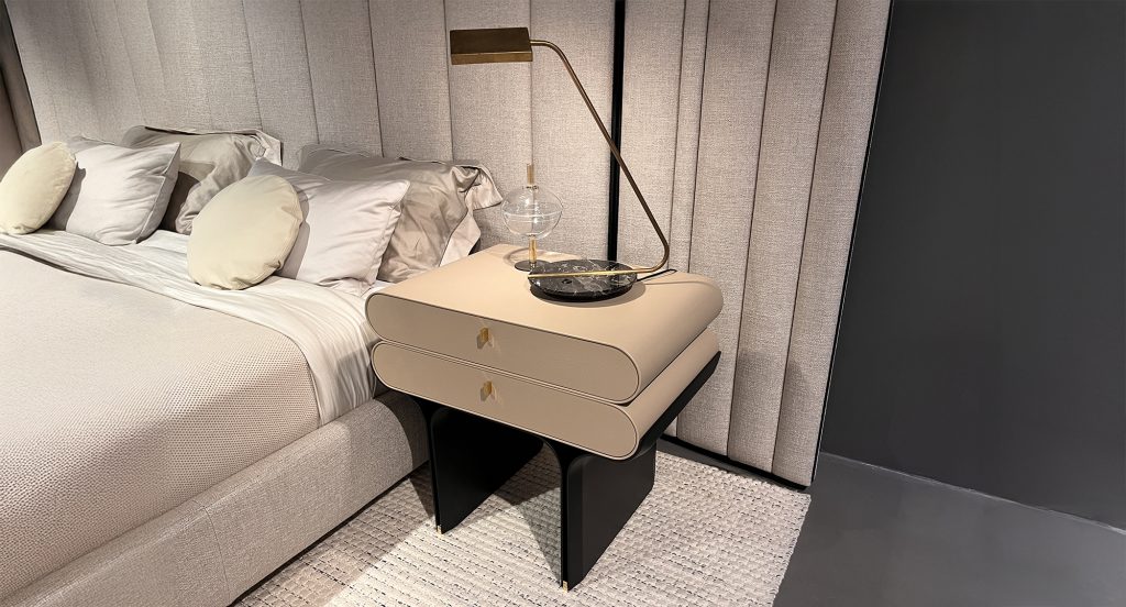 This two drawer nightstand blends soft rounded edges with a refined neutral tone. The light beige body is accented by subtle gold pulls and a bold black base, creating elegant contrast while offering practical bedside storage in a compact form.