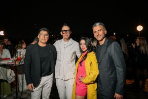 A lively evening gathering captures a stylish group posed against a vibrant social backdrop. Elegant attire, warm lighting, and relaxed expressions convey a sense of celebration, creativity, and contemporary urban culture.